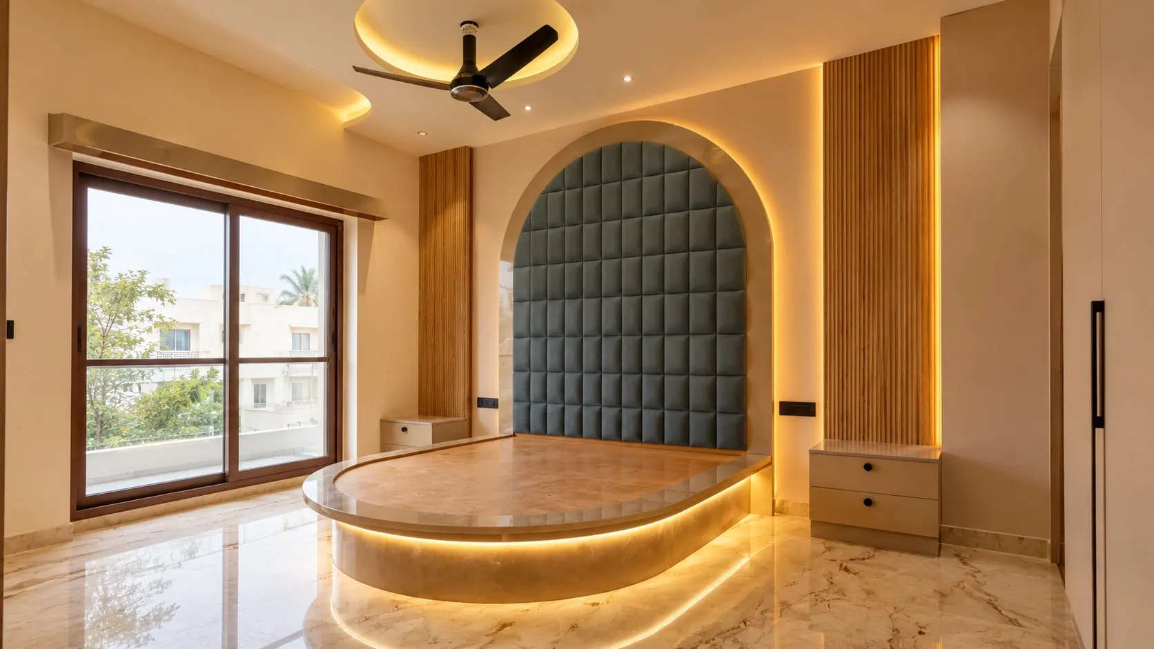 A bedroom with an arched, upholstered headboard wall and a lit platform bed